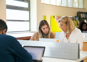 Skolniece un skolotāja pie datora